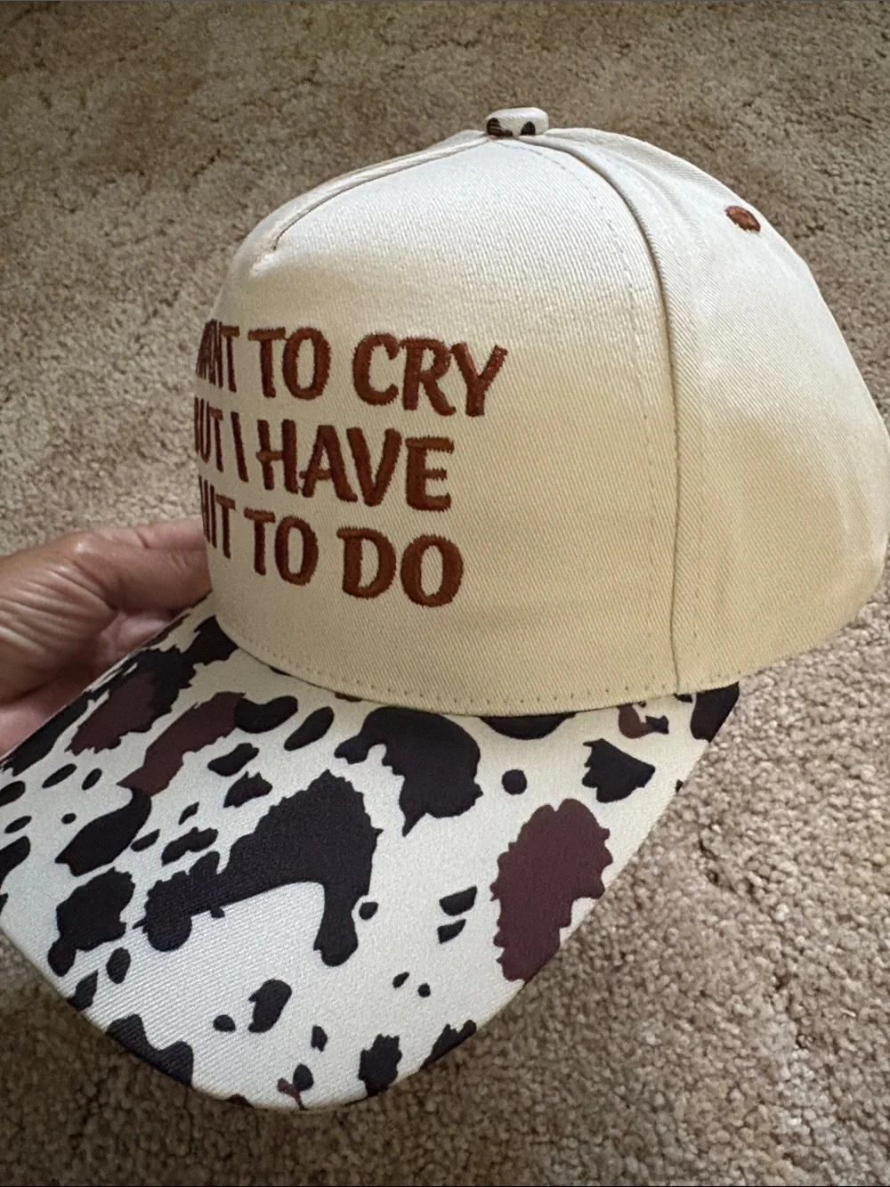 Embroiled Cream and Brown Cow Print Trucker Hat with Bold Quote
